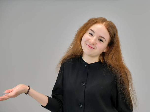 Concept portrait of a cute pretty teenager girl with red hair on a gray background smiling and talking. - Фото, зображення