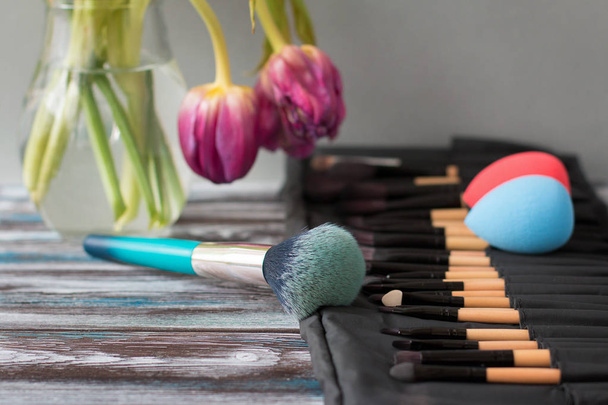 Cepillos y esponjas cosméticos profesionales sobre una mesa de madera
 - Foto, Imagen