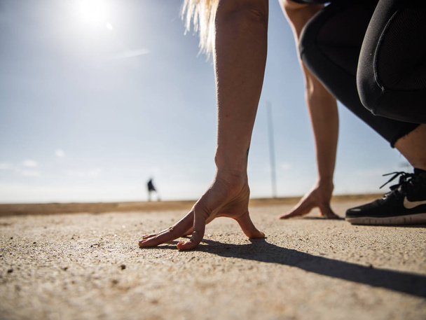vista recortada de la mujer atlética en posición de partida para correr
 - Foto, imagen
