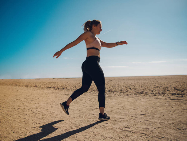 young sportswoman training on sandy beach  - Valokuva, kuva