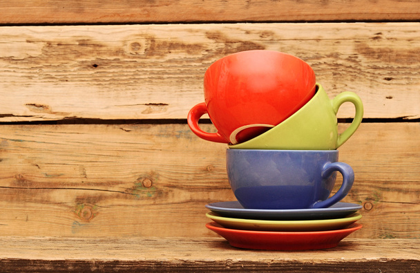 Colorful coffee mugs over an grunge wooden background - Photo, Image