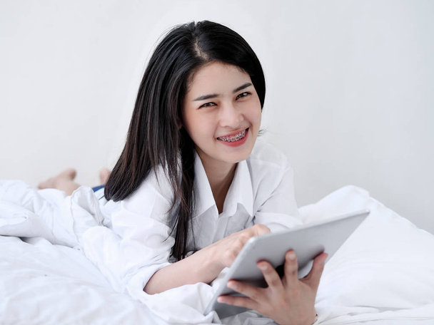 Asian woman laying on bed with tablet, lifestyle concept - Фото, зображення