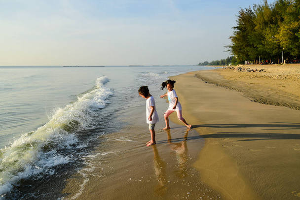 Onnellinen Aasian lapset nauttivat rannalla aamulla
. - Valokuva, kuva