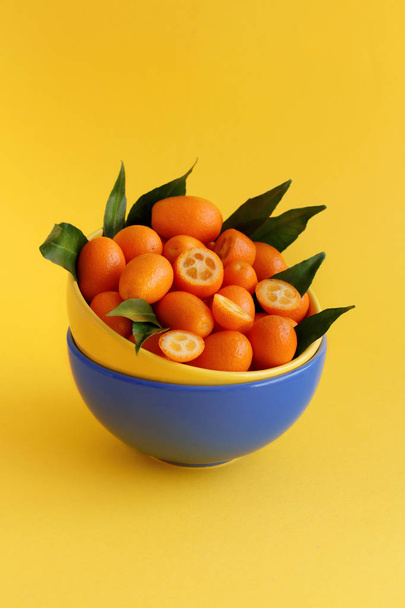 Kumquat fruits on a yellow background - Foto, immagini