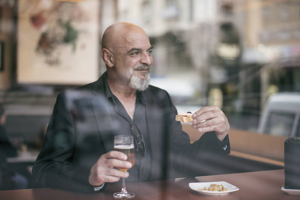 Mature man in a cafe enjoying a relaxing moment - Foto, imagen