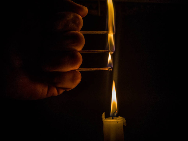 Streichhölzer brennen, um eine Kerze anzuzünden - Foto, Bild