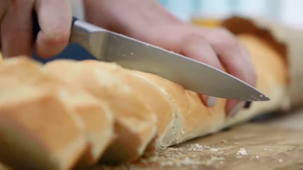 Vrouw bezuinigingen witbrood op houten snijplank, handen close-up. - Video