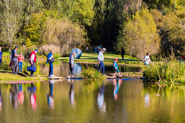 Diverse People crossing a lake at outdoor festival - Foto, Imagem