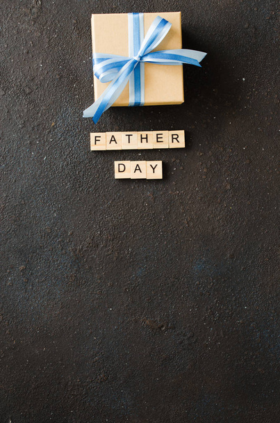 Happy Fathers päivä onnittelukortti koristeltu lahjapaketti tummalla taustalla
. - Valokuva, kuva
