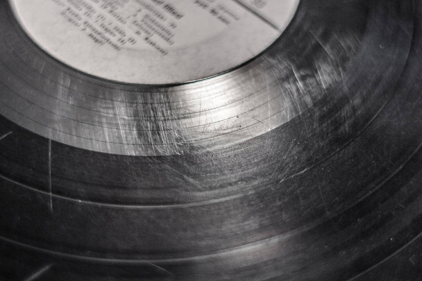 Scratches on a vinyl record. Sound track on vinyl. Old record for gramophone. Spoiled music carrier. DJ's job. The texture of the vinyl record. - Photo, Image