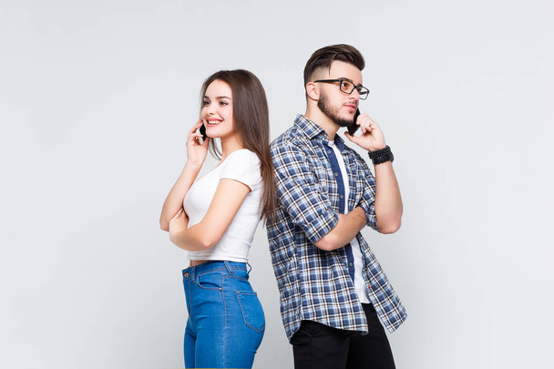 ute woman and handsome man in jeans shirts standing back to back isolated on white background - Fotó, kép