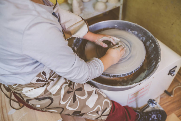 молоді гончарні руки, що працюють з глиною на гончарному колесі
 - Фото, зображення
