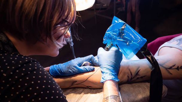 Tattoo artist make tattoo in studio, tattooing on the body. - 写真・画像