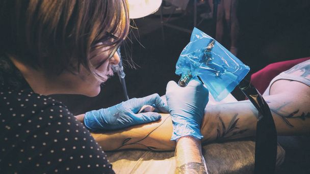 Tattoo artist make tattoo in studio, tattooing on the body. - 写真・画像