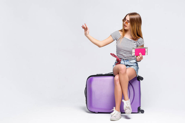 Woman preparing for summer vacation with violet suitcase isolated on white background - Foto, Imagem