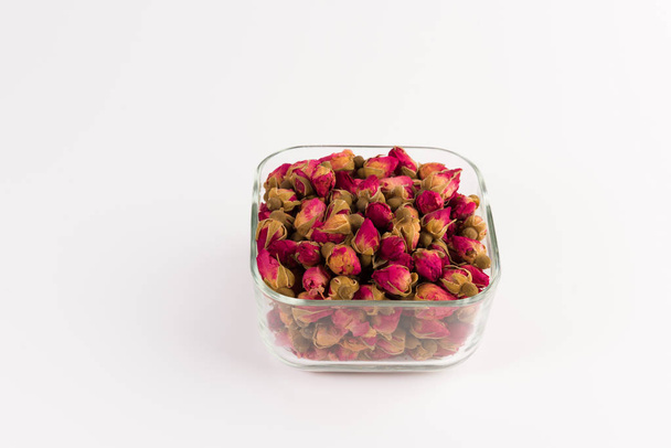 tea rose buds in a glass drinking bowl  isolated on white  background - Фото, изображение