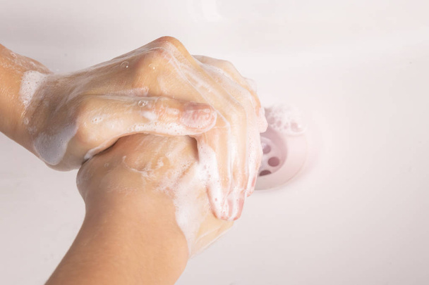 Teenager si lava le mani con il sapone nel lavandino in bagno
. - Foto, immagini
