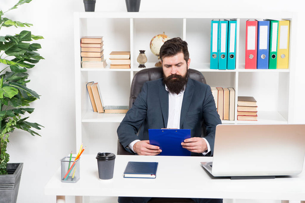 Check list. Man bearded hipster boss sit in leather armchair office interior. Boss at workplace. Manager formal clothing corporate style working. Business people concept. Busy boss in office - 写真・画像
