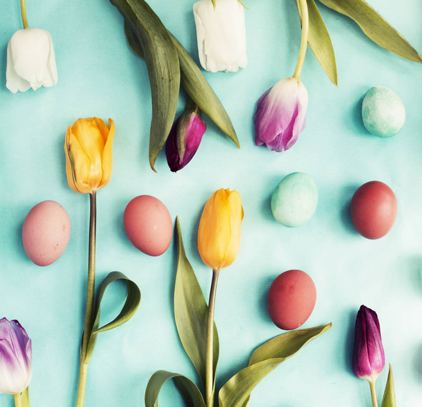 Easter flat lay with eggs and tulip flowers on spring blue background - Fotó, kép