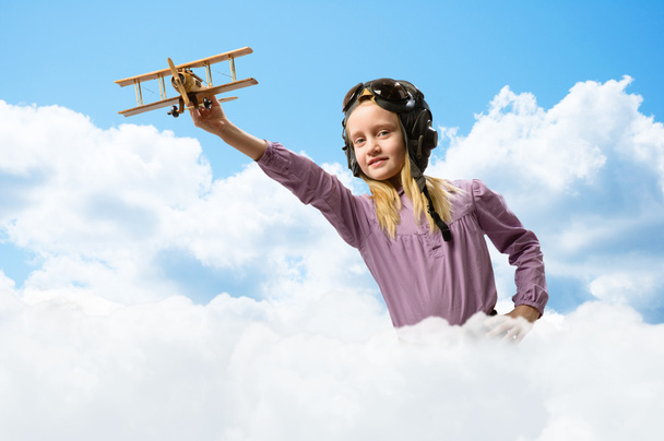 lány sisak kísérleti játszik egy játék repülőgép - Fotó, kép