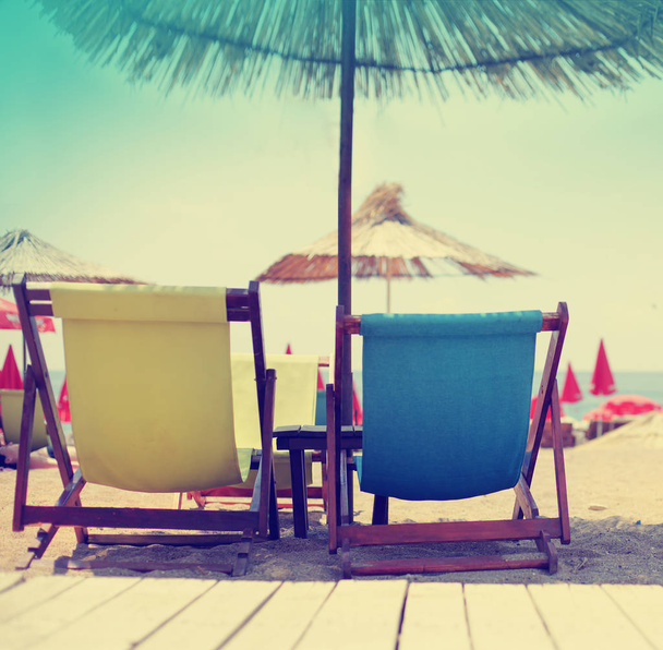 Summer vacation background with beach chairs on resort coast - Foto, Imagem