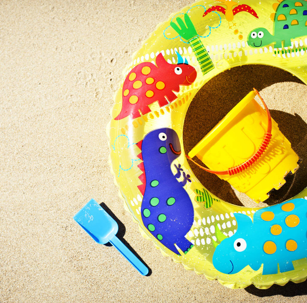 Childish toys on beach sand in sunlight, summer vacation concept - Photo, Image