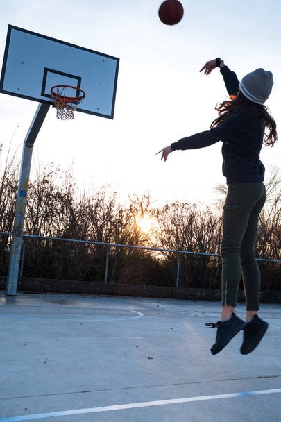 Young teen girl is playing basketball outside - Photo, Image