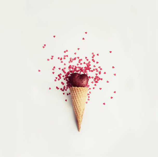 Valentines day flat lay arrangement with heart in waffle cone with red festive confetti  - 写真・画像