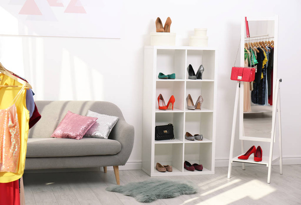 Shelving unit with shoes and purses in stylish dressing room interior - Фото, зображення