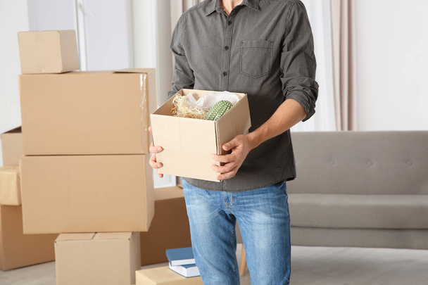 Man with moving box in his new house, closeup view - Valokuva, kuva