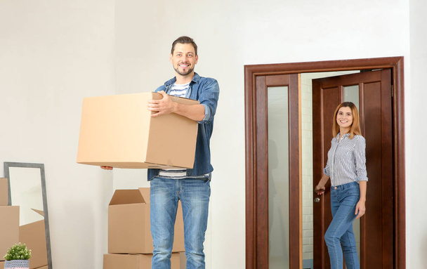 Couple walking into their new house with moving boxes - Photo, Image