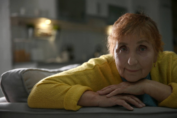 Retrato de mulher idosa no sofá em casa
 - Foto, Imagem