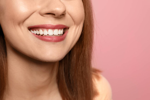 Mujer sonriente con dientes perfectos sobre fondo de color, primer plano. Espacio para texto
 - Foto, Imagen
