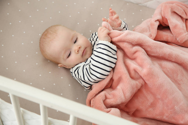 Cute baby girl in crib. Bedtime schedule - Photo, image