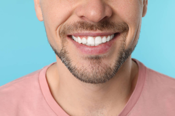 Smiling man with perfect teeth on color background, closeup - Foto, Imagem