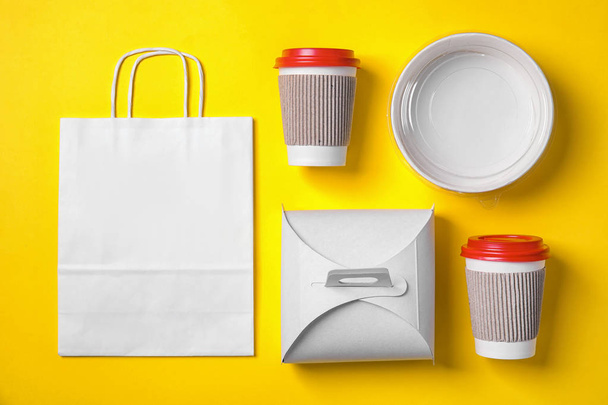 Different containers for mock up design on yellow background, flat lay. Food delivery service - Фото, зображення