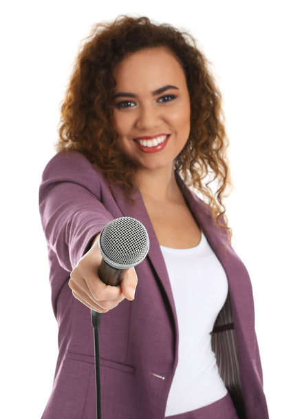 Curly African-American woman in suit with microphone on white background - Foto, imagen