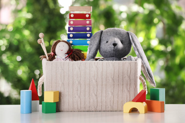 Box and different toys on table against blurred background - Photo, Image