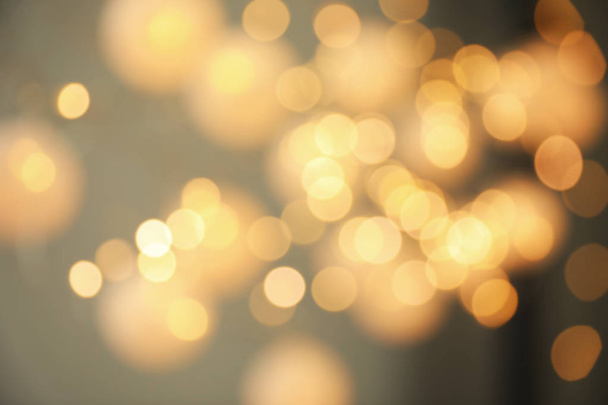 Blurred view of gold lights on dark background. Bokeh effect - Foto, afbeelding