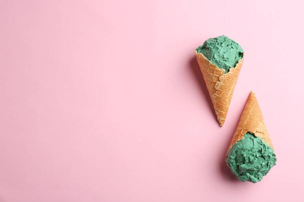 Delicious spirulina ice cream cones on color background, top view. Space for text - Фото, изображение