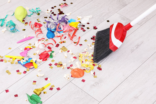 Sweeping trash after party with bristle broom indoors - Photo, image