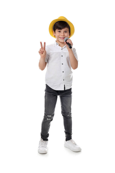 Cute little boy singing into microphone on white background - Foto, Imagen