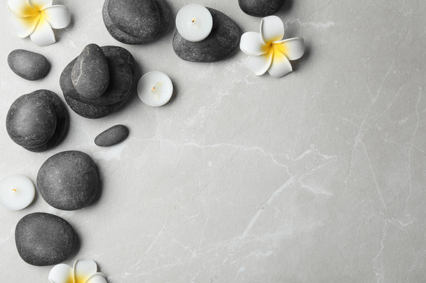 Flat lay composition with spa stones, candles and space for text on grey background - Foto, afbeelding