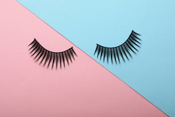 Artificial eyelashes on color background, top view - Φωτογραφία, εικόνα