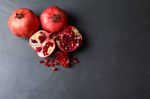 Ripe pomegranates on grey background, top view with space for text - Foto, Imagen