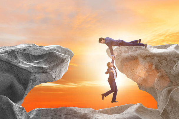 Businessman offering helping hand to falling colleague - Photo, Image