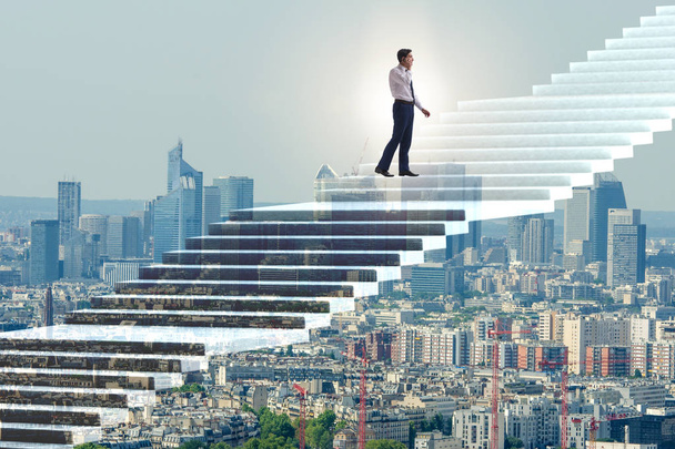 Бизнесмен поднимается по карьерной лестнице над городом
 - Фото, изображение