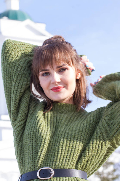 Όμορφη νεαρή κοπέλα σε ένα πράσινο πουλόβερ - Φωτογραφία, εικόνα