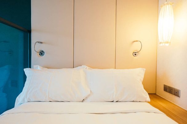 Travesseiro confortável branco na decoração da cama
 - Foto, Imagem