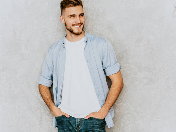 Portrait of handsome smiling hipster lumbersexual businessman model wearing casual shirt clothes. Fashion stylish man posing against gray wall - Foto, Imagen